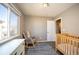 Bright bedroom featuring a wood crib, rocking chair, dresser, and large window at 200 N Holcomb St, Castle Rock, CO 80104