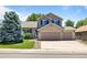 Charming two-story home with a brick facade and well-manicured lawn and an attached two car garage at 20858 E Progress Ave, Centennial, CO 80015