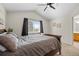 Vaulted ceiling main bedroom features neutral carpet, ceiling fan, and view to attached bathroom at 20858 E Progress Ave, Centennial, CO 80015