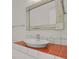 Clean bathroom with a white vessel sink and orange tile at 130 N Pearl St # 404, Denver, CO 80203