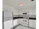 Clean kitchen with white cabinets, granite countertops, and modern appliances at 130 N Pearl St # 404, Denver, CO 80203