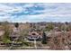 Aerial view of neighborhood featuring charming home surrounded by mature trees under a sky with scattered clouds at 4267 Federal Blvd, Denver, CO 80211