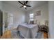 Comfortable bedroom with hardwood floors, ceiling fan, and an adjoining bathroom with tiled shower at 4267 Federal Blvd, Denver, CO 80211