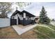 Corner view of a charming home with a covered porch, black and white brick, and landscaped front yard at 4267 Federal Blvd, Denver, CO 80211