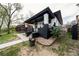 Angle view of a charming home featuring a covered porch, black and white brick, and landscaped garden with lilacs at 4267 Federal Blvd, Denver, CO 80211