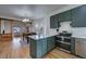 Kitchen with hardwood floors, green cabinets, quartz counters, stainless appliances, and open floorplan at 4267 Federal Blvd, Denver, CO 80211