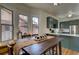 Eat-in kitchen with green cabinets, stainless appliances, adjacent to dining area and natural light at 4267 Federal Blvd, Denver, CO 80211