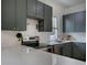 Updated kitchen featuring stylish green cabinets and stainless steel appliances under bright lighting at 4267 Federal Blvd, Denver, CO 80211