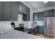 Well-lit kitchen features stainless steel appliances, quartz counters, and dark green cabinets with gold hardware at 4267 Federal Blvd, Denver, CO 80211