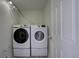 Bright laundry room featuring a modern, stacked washer and dryer and crisp white walls at 4267 Federal Blvd, Denver, CO 80211