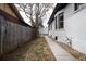 Side yard featuring a new concrete walkway, freshly painted white brick, gravel, and a wooden fence at 4267 Federal Blvd, Denver, CO 80211