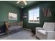 Bedroom with charming gold crib, comfortable chair, and natural light at 944 Alpine Ridge St, Erie, CO 80516