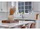 Bright kitchen featuring a center island with a sink and dishwasher next to a large window at 944 Alpine Ridge St, Erie, CO 80516