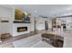Open-concept living room featuring a fireplace, mounted TV, and a modern kitchen at 944 Alpine Ridge St, Erie, CO 80516