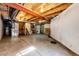 Unfinished basement space featuring exposed beams, utilities, and concrete flooring at 5660 S Algonquian Way # C, Aurora, CO 80016