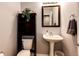 Cozy powder room includes pedestal sink, framed mirror, storage, and decorative accents at 5660 S Algonquian Way # C, Aurora, CO 80016