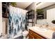 Hall bathroom with a shower and tub, shelves, vanity, mirror and nature themed decor at 5660 S Algonquian Way # C, Aurora, CO 80016