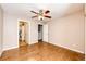 Spacious bedroom featuring hardwood floors and a ceiling fan, with doors leading to a bathroom and closet at 5660 S Algonquian Way # C, Aurora, CO 80016