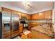 Bright kitchen with stainless steel appliances, ample wood cabinetry, granite countertops, and unique flooring at 5660 S Algonquian Way # C, Aurora, CO 80016