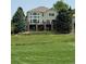 Back of the house featuring a deck, covered patio, mature trees, and green grass at 6323 S Sicily Way, Aurora, CO 80016