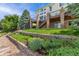 Beautiful backyard featuring a well-maintained lawn and lush landscaping with a multi-tiered wooden deck at 6323 S Sicily Way, Aurora, CO 80016