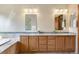 Bathroom featuring double sinks, framed mirrors, and neutral countertops at 6323 S Sicily Way, Aurora, CO 80016