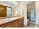 Bathroom with walk-in shower, granite counter, and wood cabinets providing a serene and functional space at 6323 S Sicily Way, Aurora, CO 80016