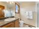Cozy bathroom featuring a frosted glass shower and wood-framed mirror at 6323 S Sicily Way, Aurora, CO 80016