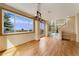 Sun-filled dining area featuring hardwood floors, a modern chandelier, and adjacent to the living room at 6323 S Sicily Way, Aurora, CO 80016