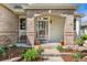 Charming front porch with brick accents, decorative plants, and ample seating at 6323 S Sicily Way, Aurora, CO 80016