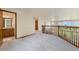 Open hallway with plush carpet and wood railing overlooking the living room at 6323 S Sicily Way, Aurora, CO 80016