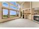 Spacious living room boasts soaring ceilings, large windows, and a cozy fireplace with custom built-ins at 6323 S Sicily Way, Aurora, CO 80016