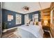 Serene bedroom with modern decor, wood accent wall, plush bedding, and ample natural light for a cozy retreat at 2942 Chase St, Wheat Ridge, CO 80214