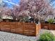 Lovely home featuring a wood fence and vibrant blooming trees providing privacy at 2942 Chase St, Wheat Ridge, CO 80214