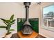 Close up of a vintage fireplace featuring green tile and hardwood floors with natural light streaming through at 2942 Chase St, Wheat Ridge, CO 80214