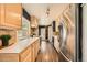 Well-lit kitchen with sleek stainless steel appliances, wooden cabinets, and a long countertop for food preparation at 2942 Chase St, Wheat Ridge, CO 80214