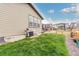 A view of the home's back yard showing the patio, barbecue, and green lawn at 23692 E 40Th Ave, Aurora, CO 80019