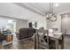 Open-concept dining room adjacent to the living room, featuring hardwood floors and modern lighting at 23692 E 40Th Ave, Aurora, CO 80019