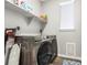 Laundry room with front loading washer and dryer and open shelving at 23692 E 40Th Ave, Aurora, CO 80019