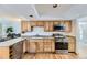 Well-lit kitchen with stainless appliances, lots of cabinets, and hardwood floors at 5749 S Lansing Way, Englewood, CO 80111