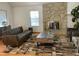 Living room featuring a stone fireplace, stylish furniture, and natural light at 5749 S Lansing Way, Englewood, CO 80111