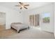 Bright bedroom features neutral carpet, a ceiling fan, and sliding glass door to the patio at 2502 S Bahama Cir # B, Aurora, CO 80013