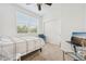 Bright bedroom features neutral carpet, a ceiling fan, and large window at 2502 S Bahama Cir # B, Aurora, CO 80013