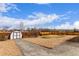 Fenced backyard with shed, gravel and concrete features and blue sky at 16555 E Wesley Ave, Aurora, CO 80013