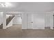 Neutral finished basement showcasing staircase, carpeting, and contemporary white door at 16555 E Wesley Ave, Aurora, CO 80013