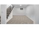View of the finished basement showcasing neutral carpet, a window, and modern staircase at 16555 E Wesley Ave, Aurora, CO 80013