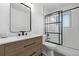 Modern bathroom featuring wood vanity, a black framed mirror and glass door shower at 16555 E Wesley Ave, Aurora, CO 80013