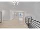 Open-concept space with modern lighting, sleek black railing, and light wood floors leading to the front door at 16555 E Wesley Ave, Aurora, CO 80013