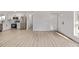 Bright, open-concept space with light wood floors leading to the kitchen, door, and large window at 16555 E Wesley Ave, Aurora, CO 80013