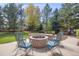 Inviting backyard with lush trees and a stylish fire pit at 1274 Meyerwood Ln, Highlands Ranch, CO 80129